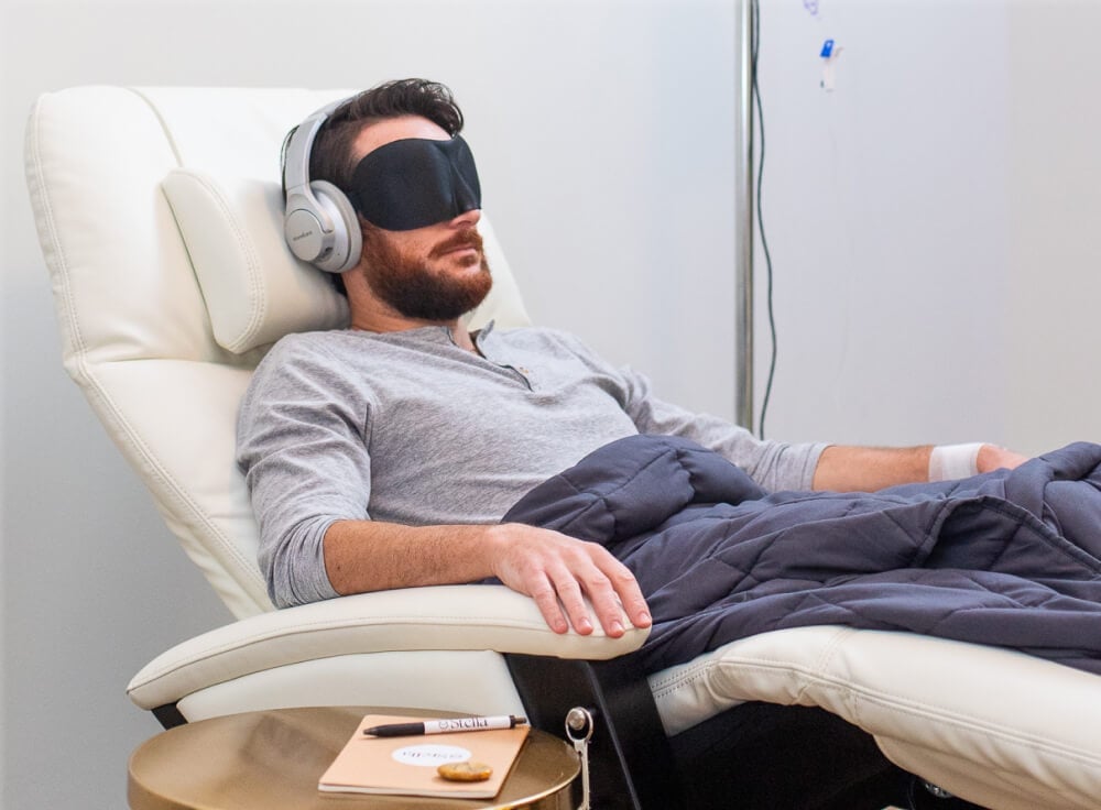 Brown hair man wearing headphones and a mask