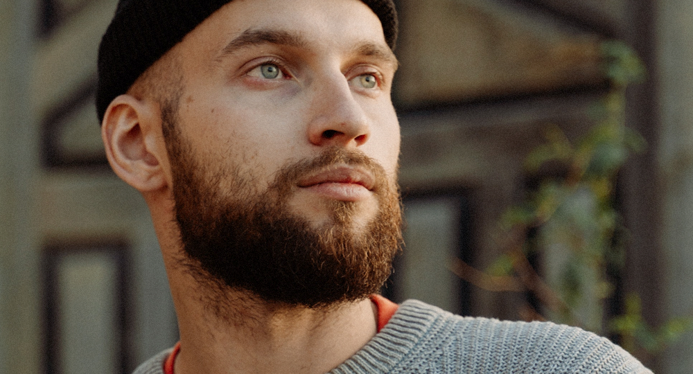 Man with a beard stares out to the sun. SGB and ketamine infusion therapy has advantages for patients